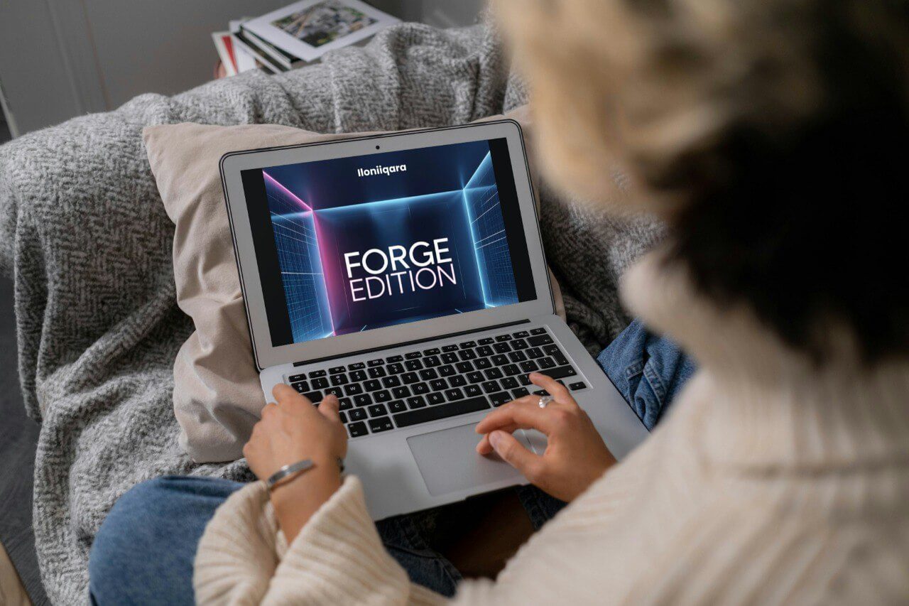Person using a laptop with 'Forge Edition' guide on the screen, sitting on a couch.